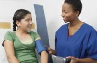 Nurse taking a girl's blood pressure