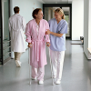 health care professional assists a patient in a hospital corridor